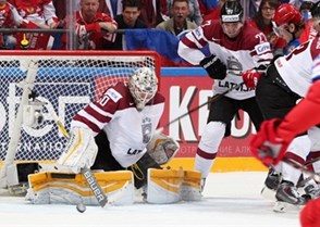 MOSCOW, RUSSIA - MAY 9: Latvia's Elvis Merzlikins #30 makes the save while Oskars Cibulskis #27 battles with Russia's Sergei Plotnikov #16 during preliminary round action at the 2016 IIHF Ice Hockey Championship. (Photo by Andre Ringuette/HHOF-IIHF Images)

